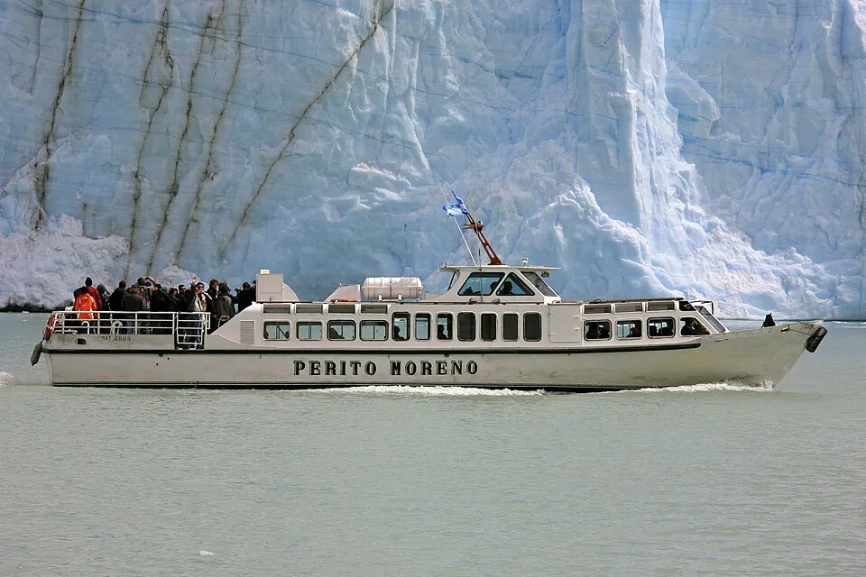 A tour boat dwarfed by the ice wall